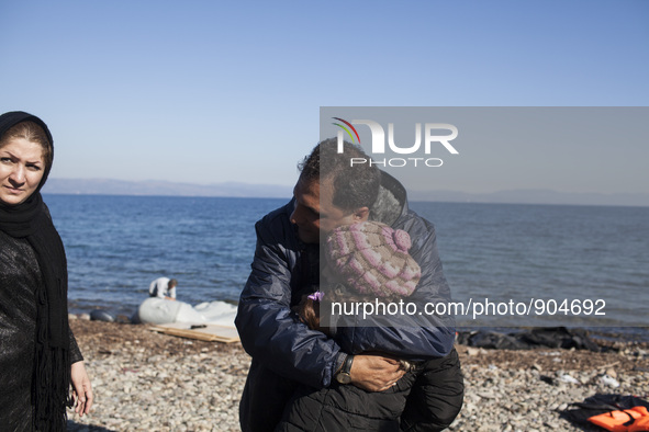 A man from Syria embraces his son as refugees and migrants riding a dinghy reach the shores of the Greek island of Lesbos after crossing the...