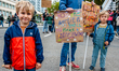 Two little boys are accompanied his father during a massive climate demonstration organize...
