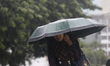 Residents make their way during a heavy rainfall in Dhaka, Bangladesh as the effects of Cy...