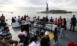 People travel a ferry from Liberty Island to Ellis Island in New York City, United States...