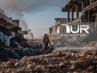 A Kurdish Peshmerga soldier searches for weapons in the rubble of an airstrike on November 14, 2015 in Sinjar, Iraq. Kurdish forces, with th...