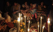 A family in front of a cover with cempasúchil flowers in a community pantheon on Janitzio...