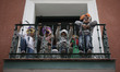 Women and children come out to the balcony with their faces covered, immediately after occ...