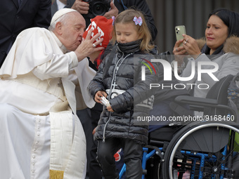 A girl holds a statuette of the Pope as Pope Francis meets with disabled attendees during the weekly general audience on November 9, 2022 at...