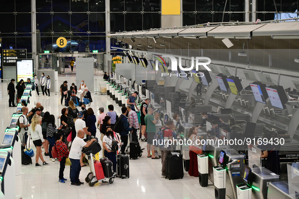 Travelers seen queue in line to check-in for flight at Suvarnbhumi International Airport on November 9, 2022 in Sumut Prakan, Thailand. 