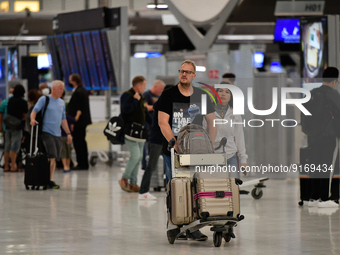 Travels seen carry their luggage inside the departure terminal of the Suvarnabhumi International Airport on November 9, 2022 in Sumut Prakan...
