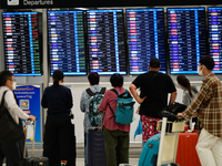 Travelers seen check departure time at Suvarnbhumi International Airport on November 9, 2022 in Sumut Prakan, Thailand. (