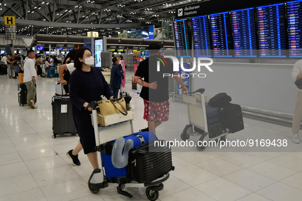 A woman seen pushes her luggage inside the departure terminal of the Suvarnabhumi International Airport on November 9, 2022 in Sumut Prakan,...