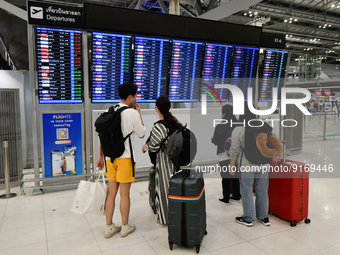 Travelers seen check departure time at Suvarnbhumi International Airport on November 9, 2022 in Sumut Prakan, Thailand. (