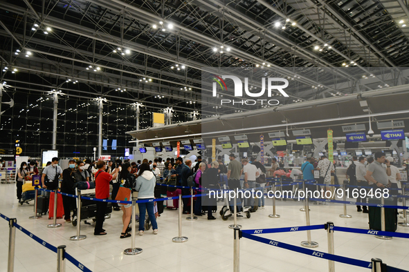 Travelers queue in line to check-in for flight at Suvarnbhumi International Airport on November 9, 2022 in Sumut Prakan, Thailand. 