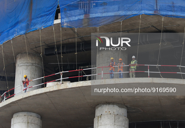 Workers work on under-construction building in Colombo on November 9, 2022. 