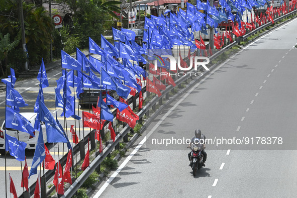 A motorcyclist rides past the party flags during the campaign period of Malaysia's general election in Kuala Lumpur on 11 November, 2022.  