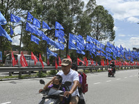 A motorcyclist rides past the party flags during the campaign period of Malaysia's general election in Kuala Lumpur on 11 November, 2022.  (