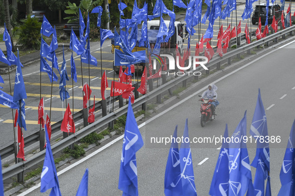 A motorcyclist rides past the party flags during the campaign period of Malaysia's general election in Kuala Lumpur on 11 November, 2022.  