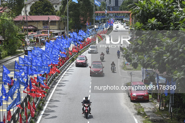 A motorcyclist rides past the party flags  during the campaign period of Malaysia's general election in Kuala Lumpur on 11 November, 2022.  