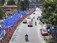 A motorcyclist rides past the party flags  during the campaign period of Malaysia's general election in Kuala Lumpur on 11 November, 2022....