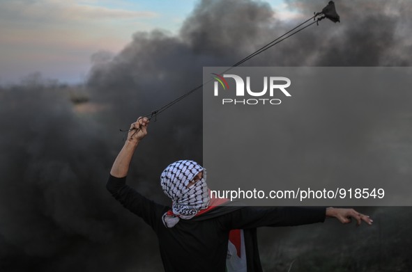 A Palestinian man uses a slingshot to launch stones at Israeli troops during clashes between Palestinians and Israeli troops along the borde...