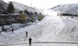 Three person near the ski slopes where the snow cannons are working after the first big sn...