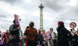 Demonstrators hold placards with feminist slogans in Place de la Bastille during a demonst...
