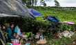 The villagers take shelter in a makeshift tent at a tea farm after Monday's earthquake hit...