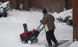 A man operates a snow blower to remove snow from a parking lot in Warsaw, Poland on 15 Dec...