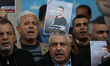 Demonstrators carry a portrait of Palestinian prisoner Nasser Abu Hamid, a cancer patient...