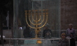 Ultra-Orthodox Jewish men light candles on the seventh night of Hanukkah in the Jewish Qua...