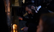 Ultra-Orthodox Jewish men light candles on the seventh night of Hanukkah in the Jewish Qua...