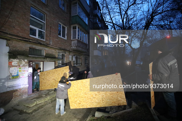 KYIV, UKRAINE - DECEMBER 31, 2022 - Men unload particle boards that will be used to replace broken windows after a Russian missile attack on...