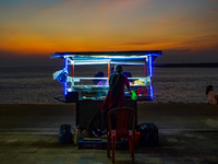 A vendor sells prawns, crabs, and rottie from his cart on the Galle Face promenade in Colombo, Sri Lanka, on January 11, 2023. (