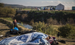 Idomeni, Greece-- December 4, 2015--An immigrant rests on the ground at Idomeni transit ca...