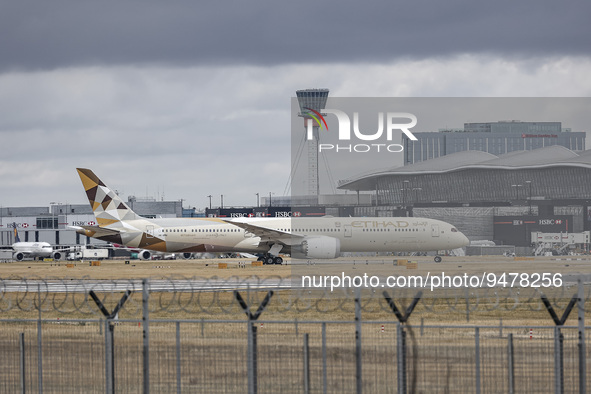Etihad Airways Boeing 787-10 Dreamliner airplane as seen taxiing in front of the terminal building and the control tower of London Heathrow...