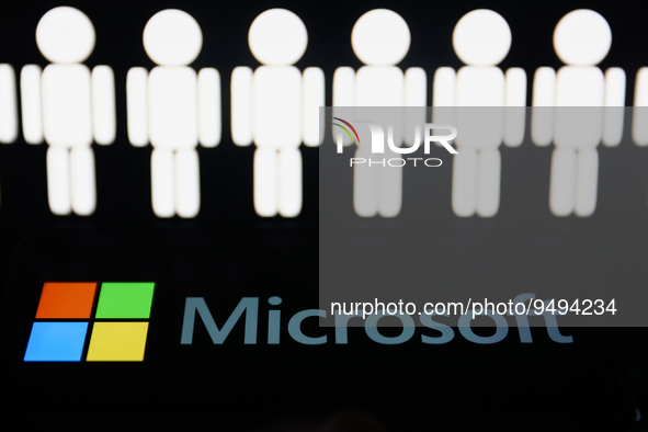 Stick figures image displayed on a laptop screen and Microsoft logo displayed on a phone screen are seen in this illustration photo taken in...