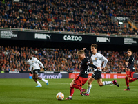 Iker Muniain (L) of Athletic Club competes for the ball with Hugo Guillamon of Valencia CF during the Copa del Rey Quarter Final match betwe...