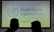 Two silhouettes are seen in front of the WHO logo on the screen, Nicosia, Cyprus, on Jan....