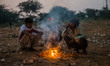 Local people burn wood and plastic as they warm themselves around a fire in Pushkar, India...