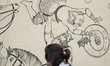 An Iranian young woman walks past a mural in downtown Tehran, January 29, 2023. Since the...