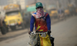 People make their move in a dusty busy road in Dhaka, Bangladesh on January 31, 2023. With...
