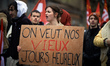 A student holds a placard reading ' We want our old happy days'. France's labour unions le...