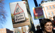 

A woman is holding a placard reading 'Factory exit' as France's labour unions and left p...