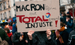 A demonstrator holds a sign with ''Macron ta reforme est totalement injuste'' (Macron your...