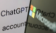 ChatGPT website displayed on a laptop screen and Microsoft logo displayed on a phone scree...