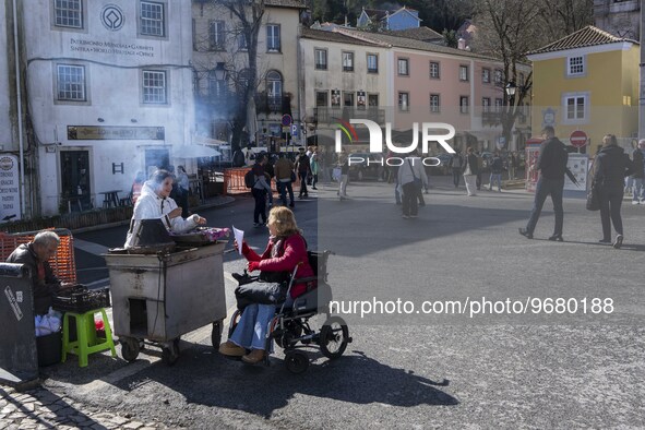 

A person is seen buying chestnuts from a vendor located in one of the streets in the historic area of Sintra, Portugal, on March 3rd, 2023...