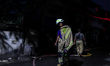 Firefighters rest after extinguishing a fire that broke out at a fuel storage station oper...