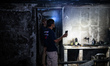 A man inspects the aftermath of his houses following a fire broke out at a fuel storage st...