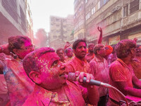 A man covered in colored powder is seen singing with a mic during Holi festival celebration in Kolkata , India , on 5 march 2023 .  Holi , a...