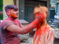 Two gboys are seen smearing each other with colored powder during Holi celebration in Kolkata , India , on 5 March 2023 . People of Kolkata...