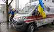 Young women from Ukraine with the Ukrainian flag around them are have an emotional reactio...