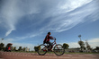 A Palestinian woman rides a bicycle at Gaza City's Yarmouk Stadium on March 7, 2023 a day...