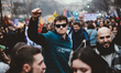 A demonstrator holds up his fist in the air in the middle of a procession of young people...